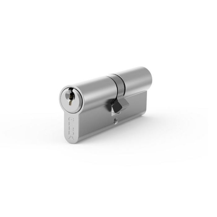 Shiny silver cylinder lock with a key partially inserted on the left, resting on a white surface.