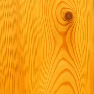 Close-up of an orange-tinted wooden surface showing grain patterns and a knot.