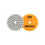 Two circular abrasive tools: a segmented metal grinding wheel and a yellow 200-grit polishing disc.