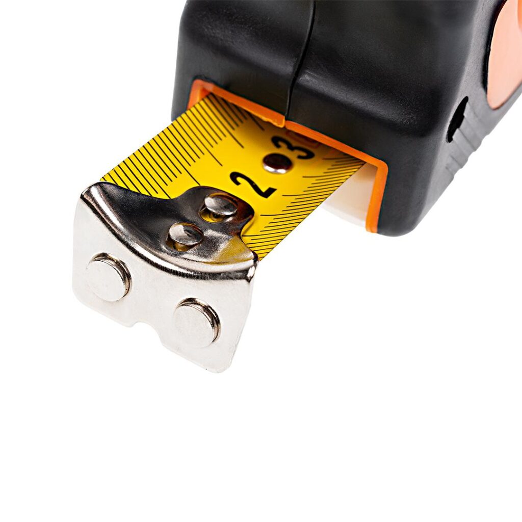 Close-up of a tape measure extended to about 2 inches, showing the yellow blade and metal end hook in a black housing.
