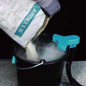 ARDEX X 26 dry mix being poured into a black bucket with a turquoise mixer attachment.