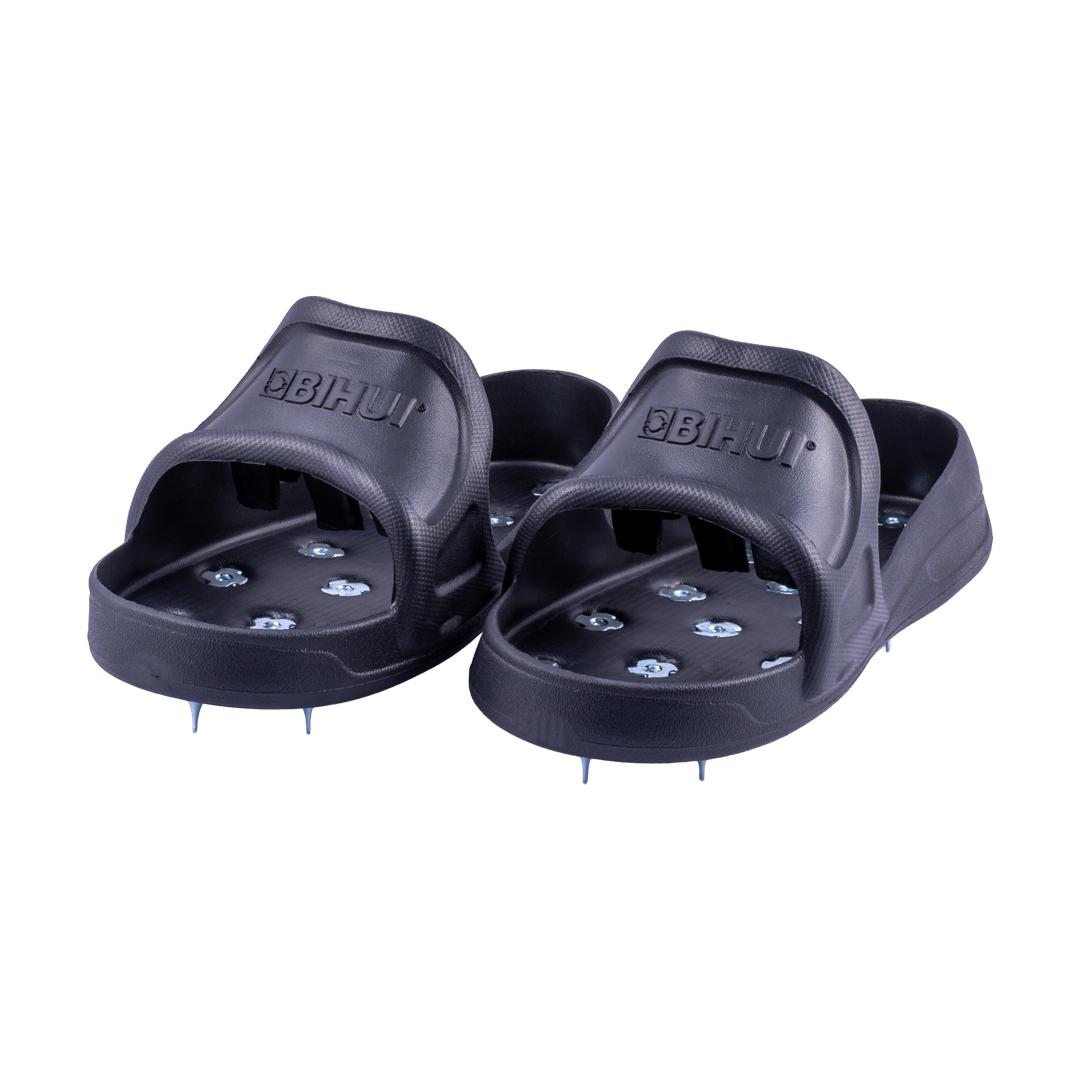 megabudowlany-bihui-buty-z-kolcami-do-wylewek-l-sklep-budowlany2 - Mega Budowlany Pair of dark slide sandals with textured straps and metal studs on the footbed, viewed from the front.
