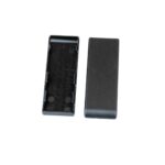 Open black plastic battery holder tray with circular coin-cell slots; lid is separate beside it.