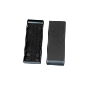 Open black plastic battery holder tray with circular coin-cell slots; lid is separate beside it.