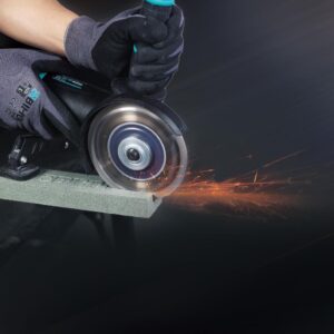 Worker wearing gloves uses a handheld grinder to cut metal, sparks flying from the cut edge.